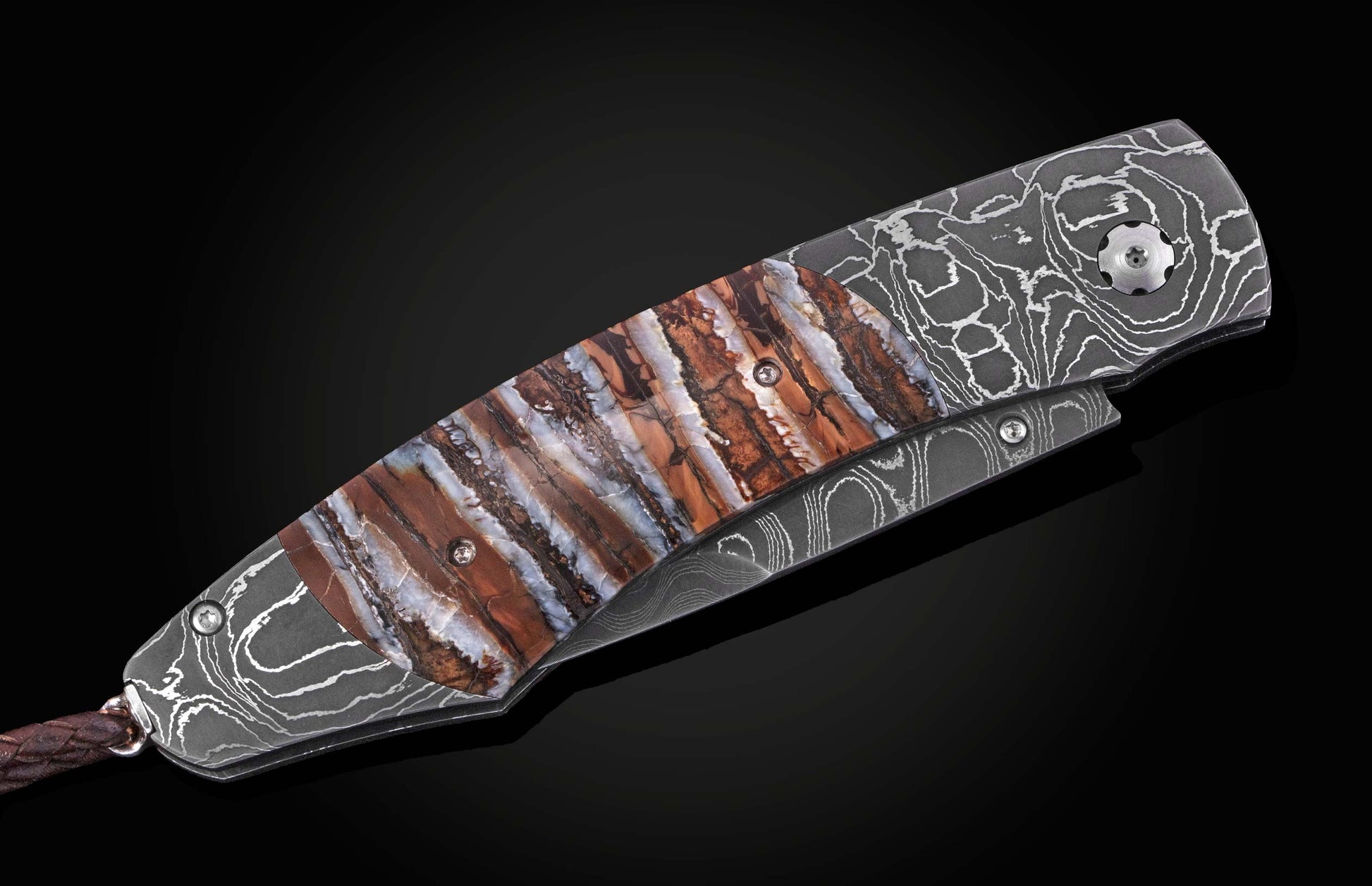 Damascus steel folding knife with grey swirled handle and multi-colored striped scales in brown, white, and grey, with a leather lanyard.