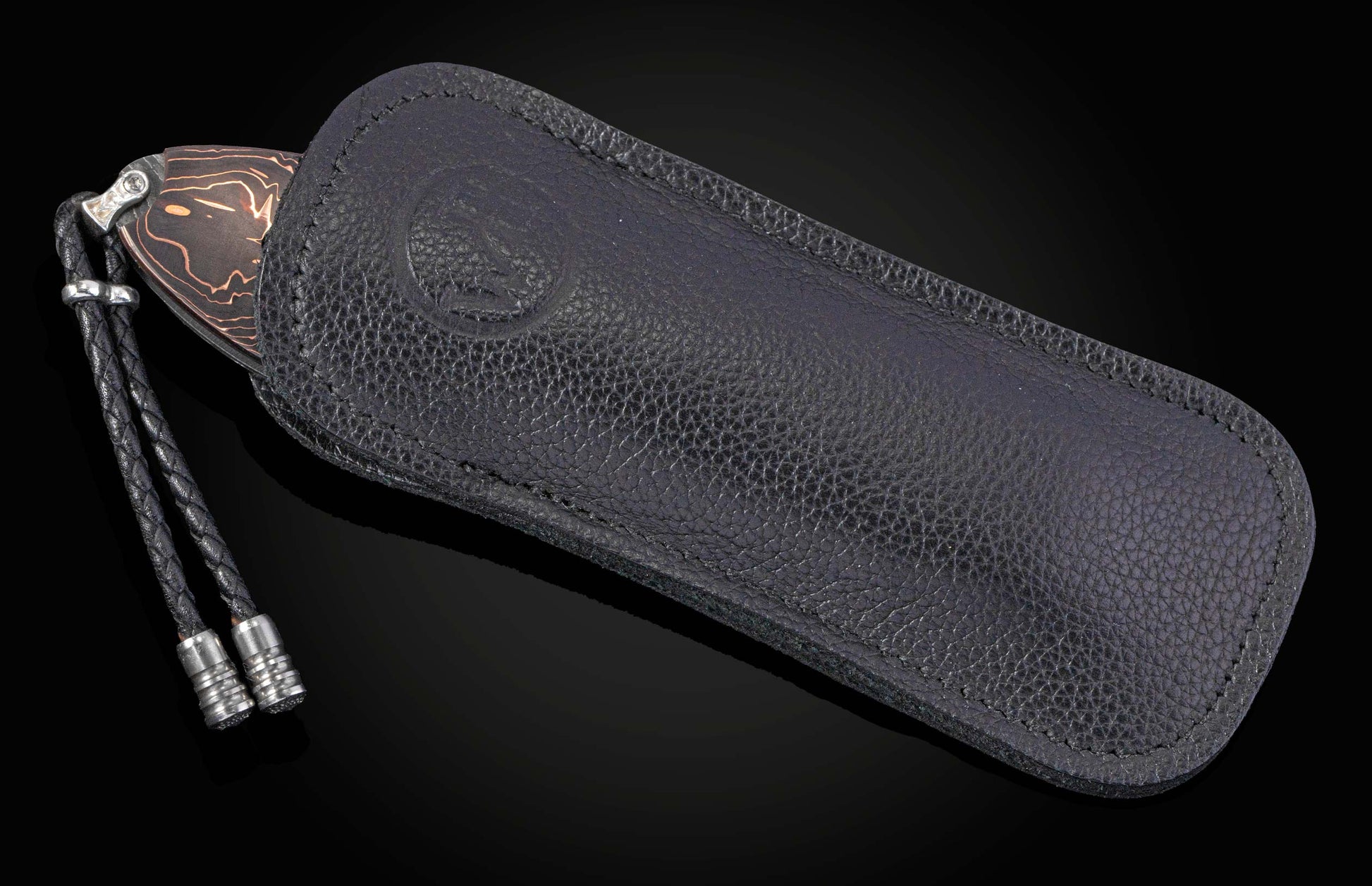 knife in a black leather case with a lanyard on a black background