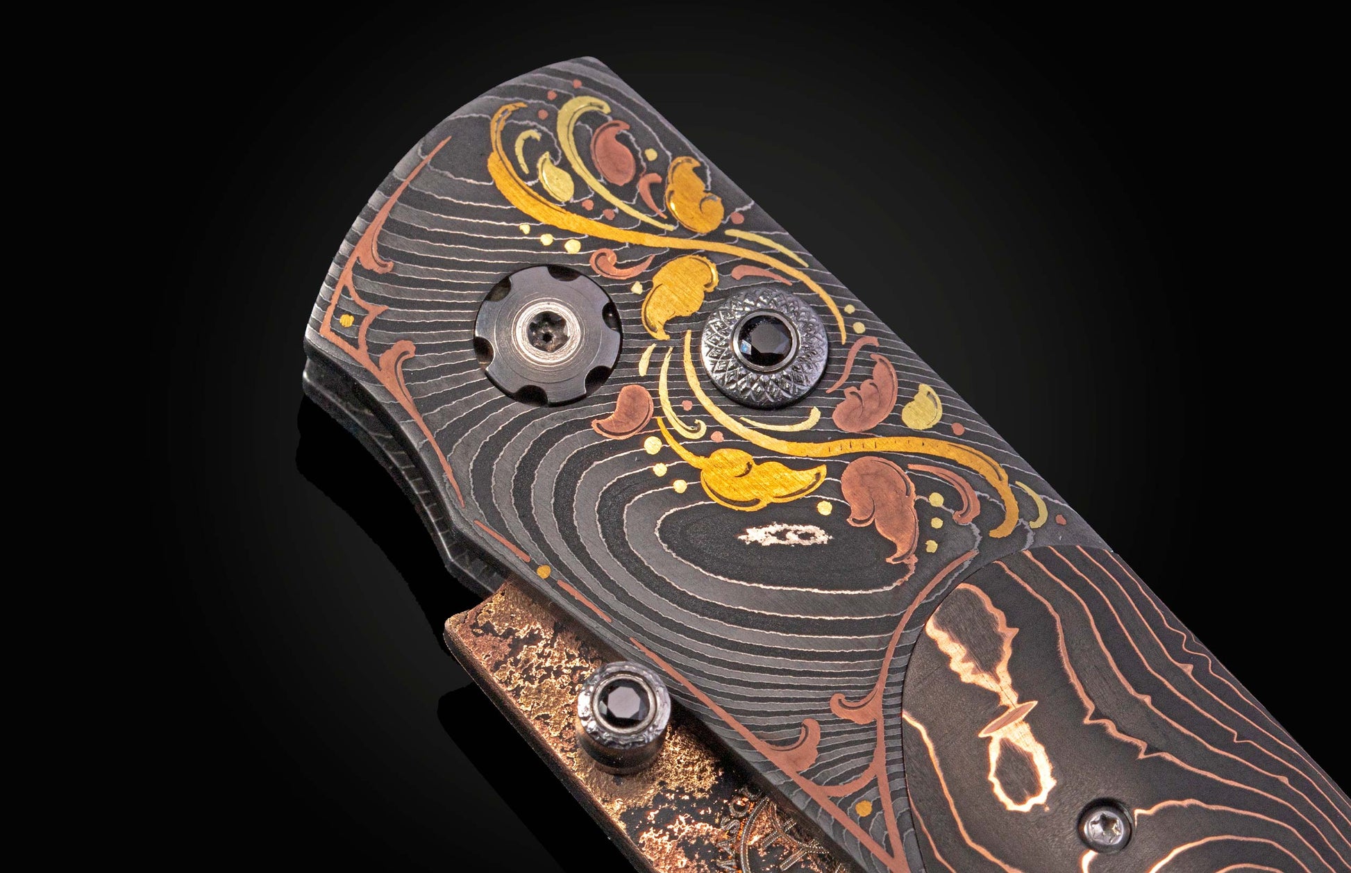 Decorative folding knife with intricate patterns on a dark background