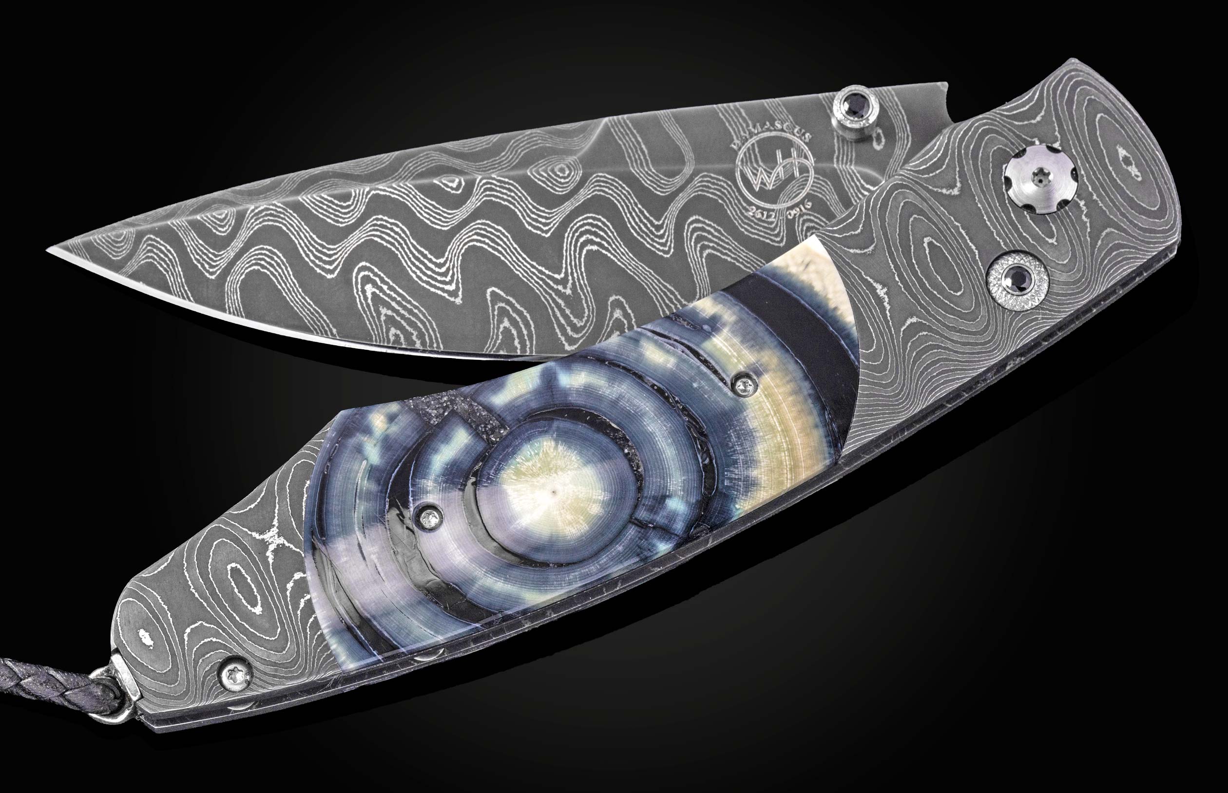 Damascus steel folding knife with blue meadow patterned handle by B12, featuring wave-like blade texture and circular inlay detail, side view on black background