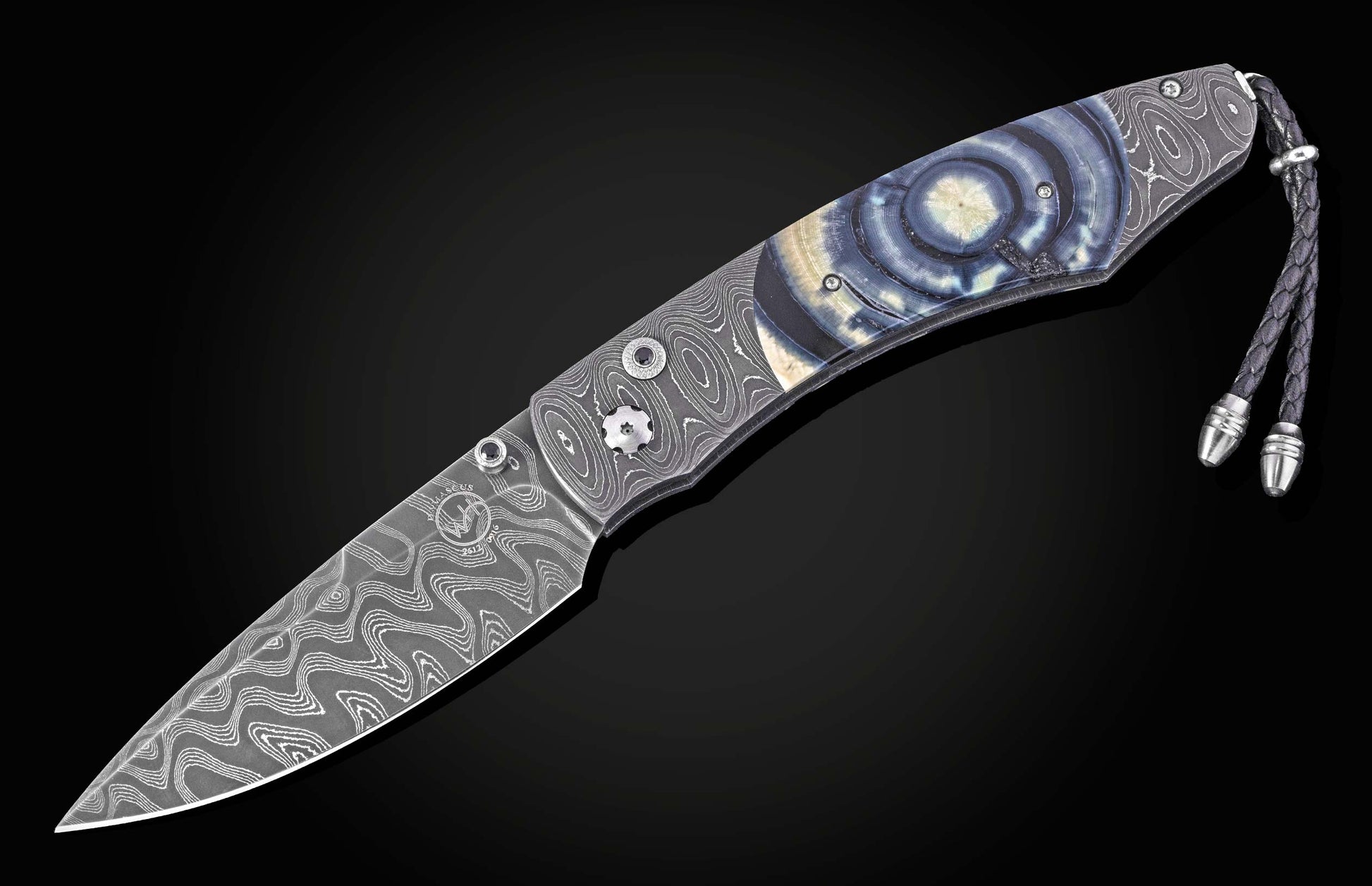 Damascus steel knife with blue agate inlay handle by B12, featuring wave-pattern blade and braided cord lanyard, side view on black background