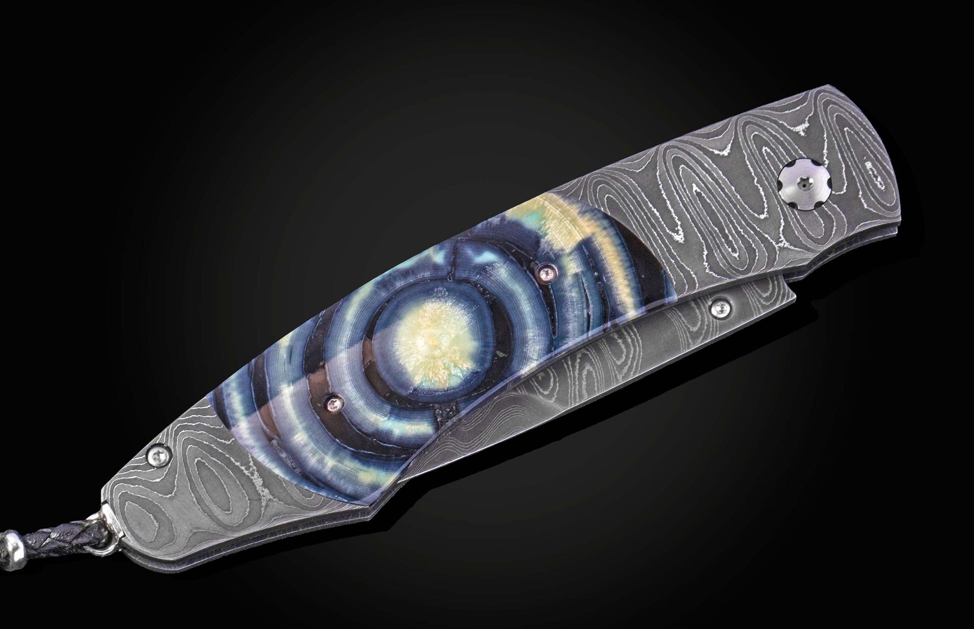 Luxury folding knife with blue and gold resin inlay, damascus steel handle, side view on black background