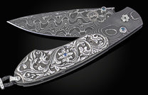 William Henry knife with hand carved sterling silver scales and damascus steel.