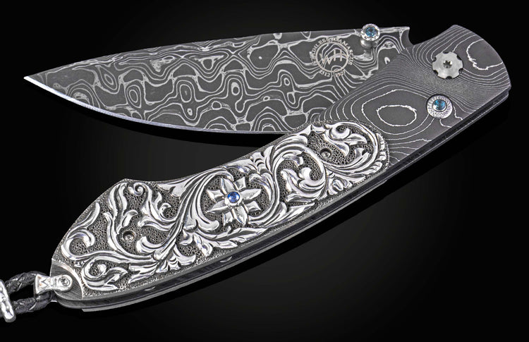 William Henry knife with hand carved sterling silver scales and damascus steel.