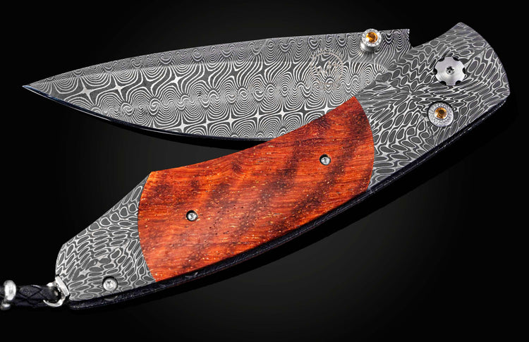 Decorative knife with a wooden handle and Damascus steel blade on a dark background