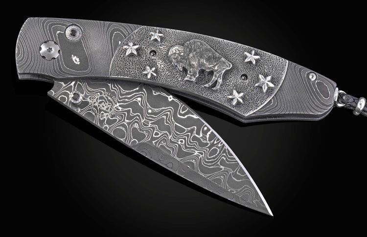 William Henry folding knife with damascus steel and hand carved sterling silver buffalo design