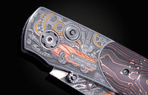 Custom knife with intricate silver engravings of a classic orange car and gears, and a dark handle with fiery orange lines.