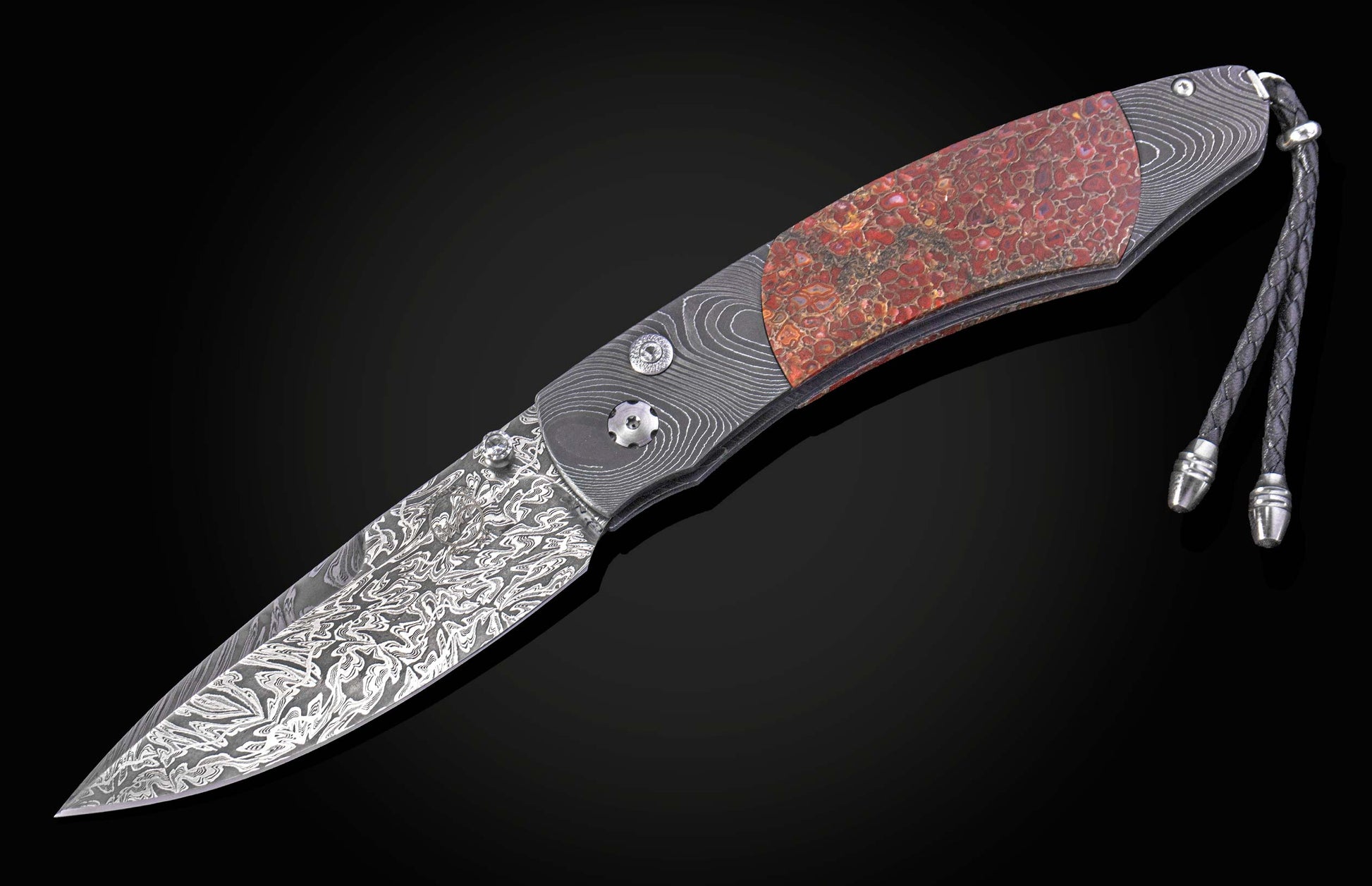Decorative knife with a damascus blade and fossilized dinosaur bone scales on a black background