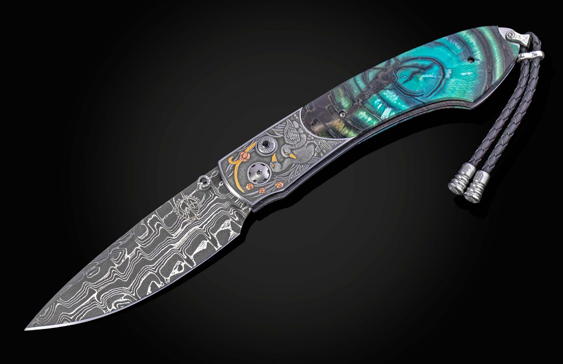 Hand engraved William Henry knife with mammoth tusk handle and damascus blade on a dark background