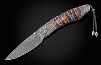 Decorative folding knife with fossil wooly mammoth tooth scales and hand carved depictions of native Americans with the blade open