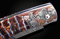 detail image of hand carving on a pocket knife depicting a cowboy on horseback and a covered wagon