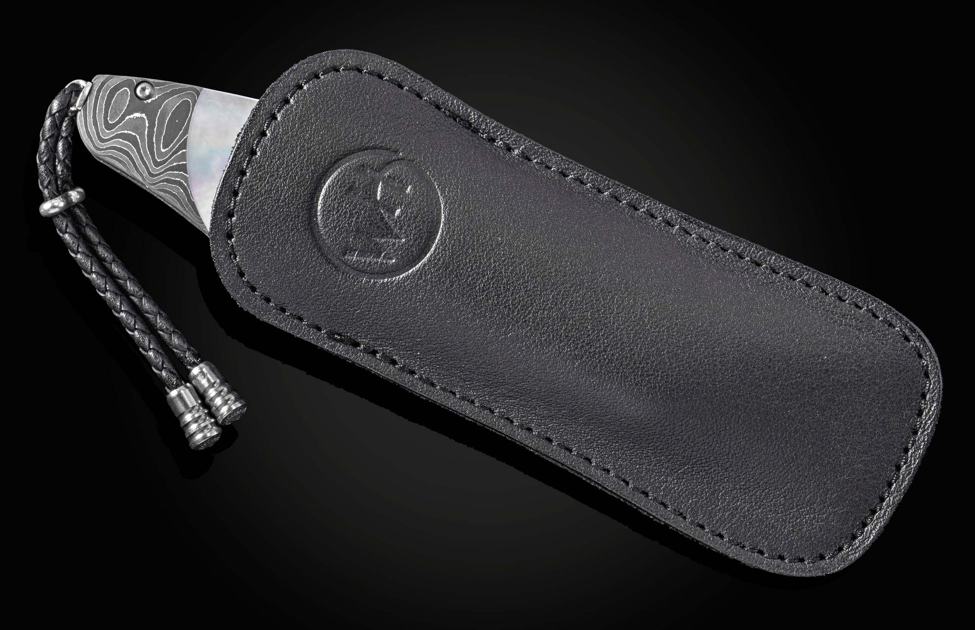 Luxury Damascus steel knife with mother-of-pearl inlay, by B12, in black leather sheath with braided cord and embossed logo, side view