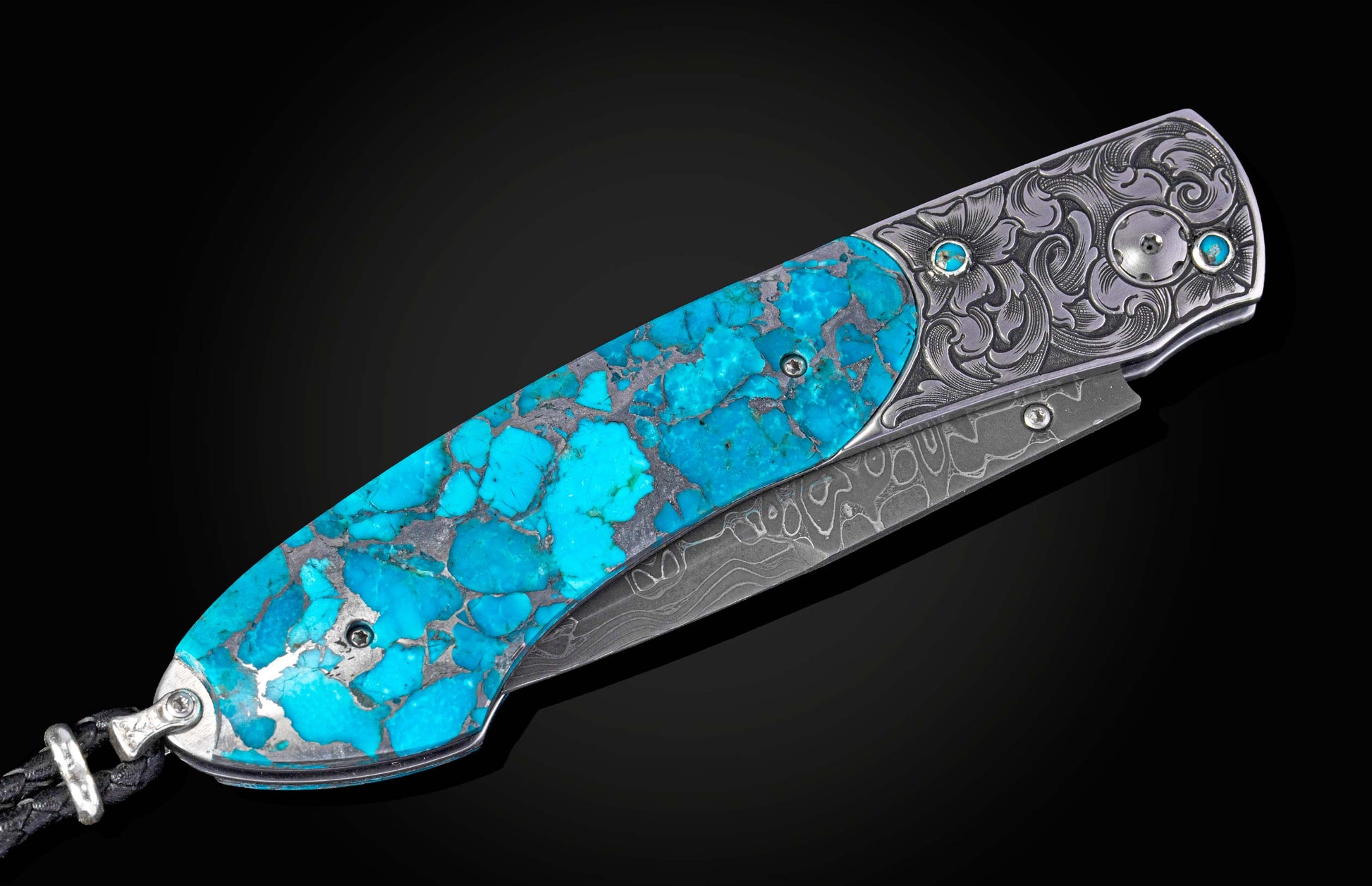 Hand engraved knife with turquoise and damascus blade shown closed on a black background