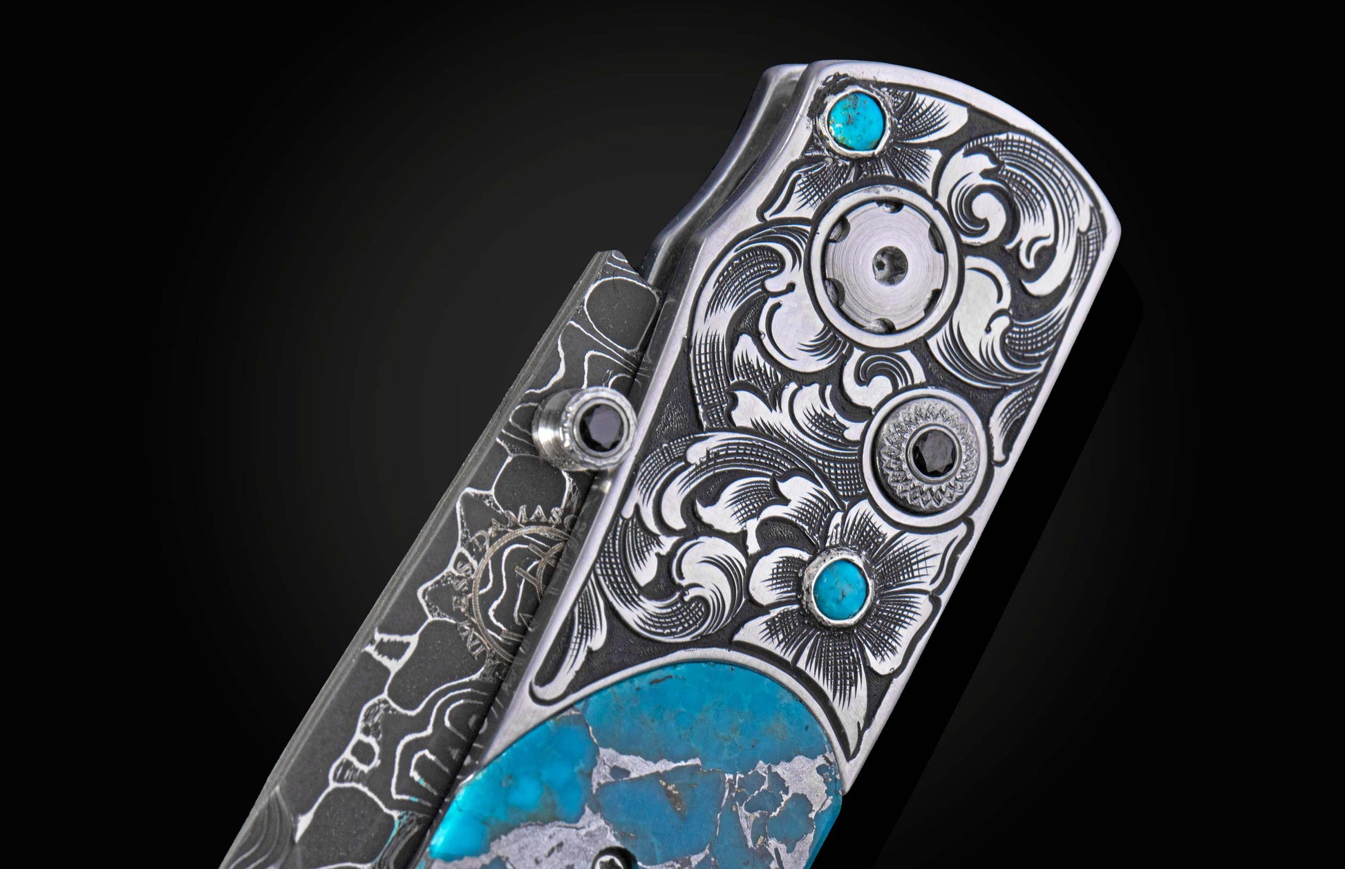 Close up of hand engraving on knife with turquoise and damascus blade