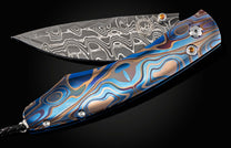 Folding knife with a Damascus steel blade and colorful handle on a black background