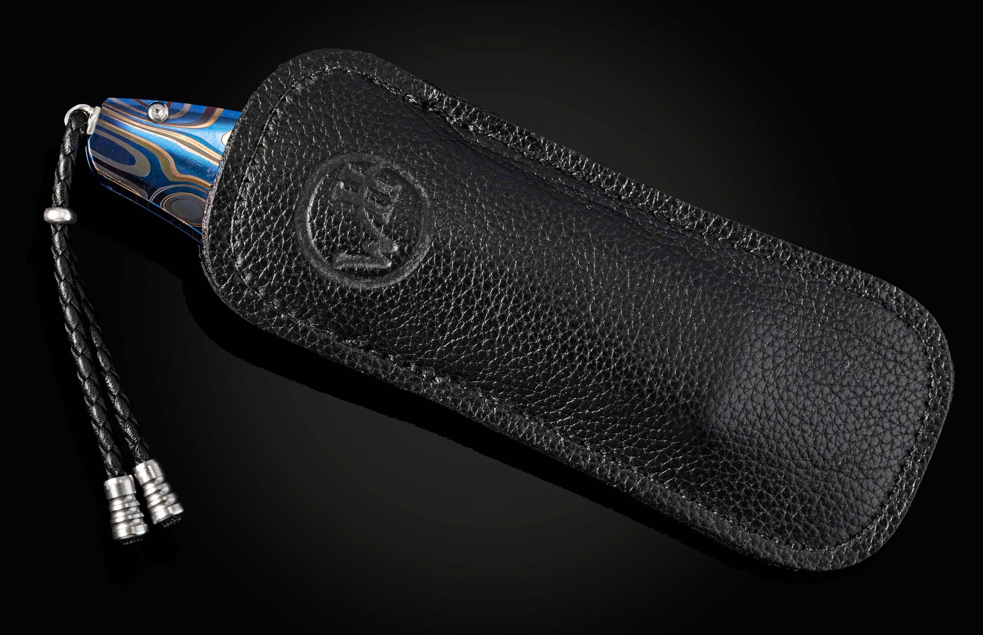 Black leather sheath with a knife featuring a blue handle on a black background
