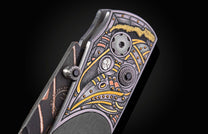 Knife with ornate silver, gold, and copper etched handle featuring gears and black gems, side view.