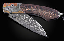 Folding knife with Damascus steel blade and hand engravings on a black background