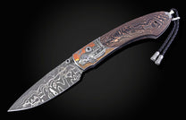 Folding knife with Damascus steel blade and hand engravings on a black background