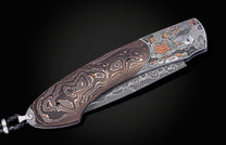 Folding knife with Damascus steel blade and hand engravings on a black background