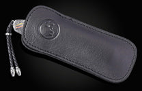 Black leather knife sheath with embossed logo and braided cord, by B12 NINE HORSES, side view on dark background