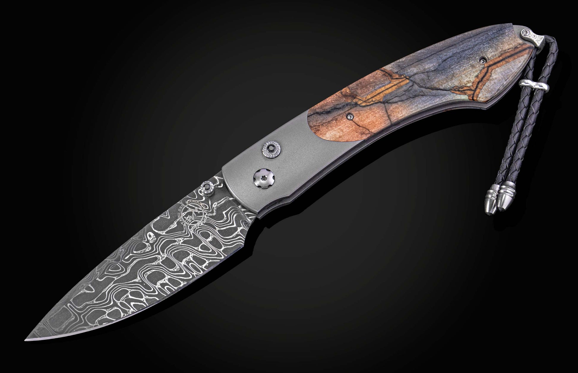 Folding knife with decorative blade and mammoth tooth handle on a black background