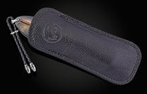 Folding knife with decorative blade and mammoth tooth handle on a black background