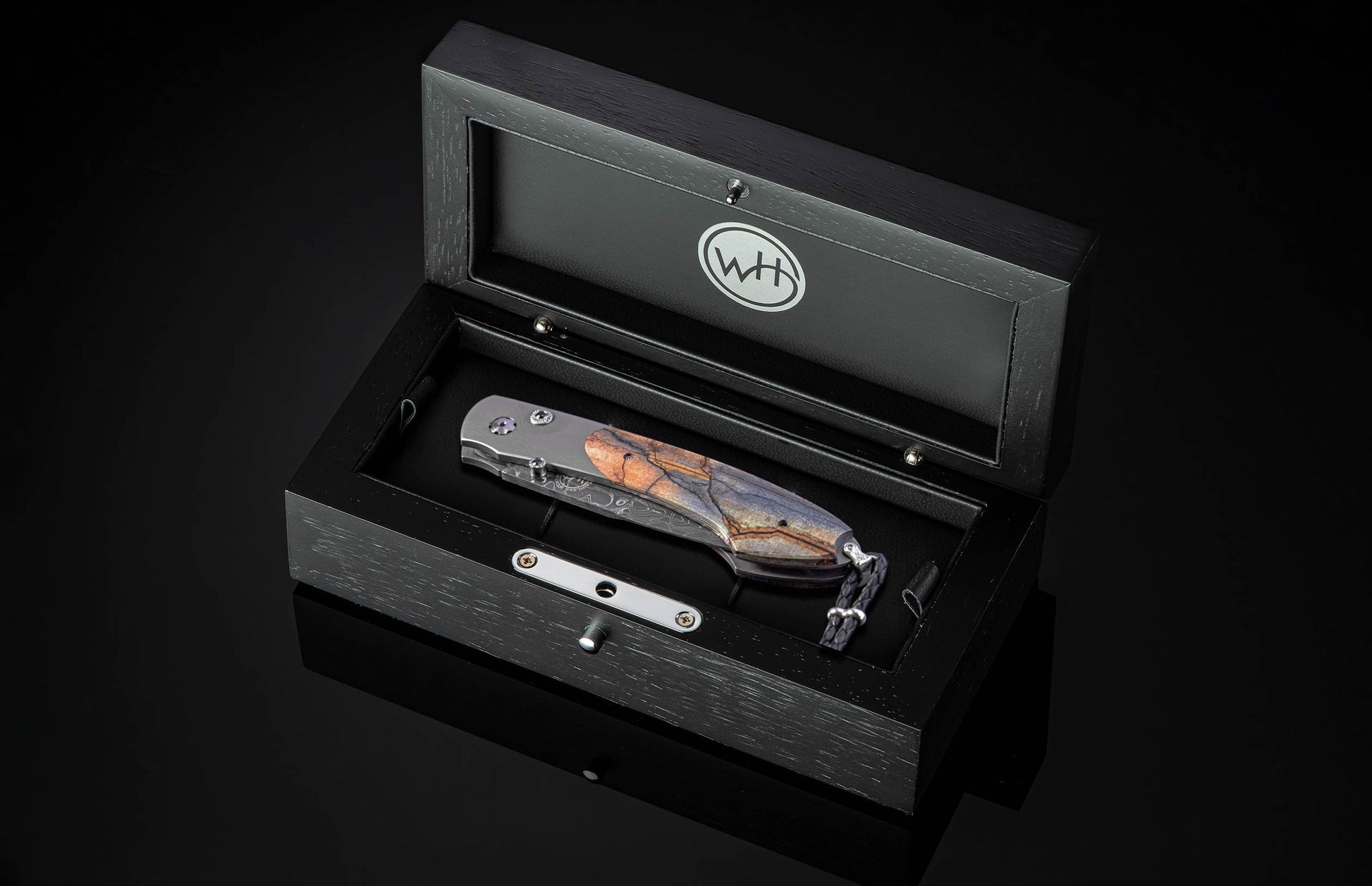 Folding knife with decorative blade and mammoth tooth handle on a black background