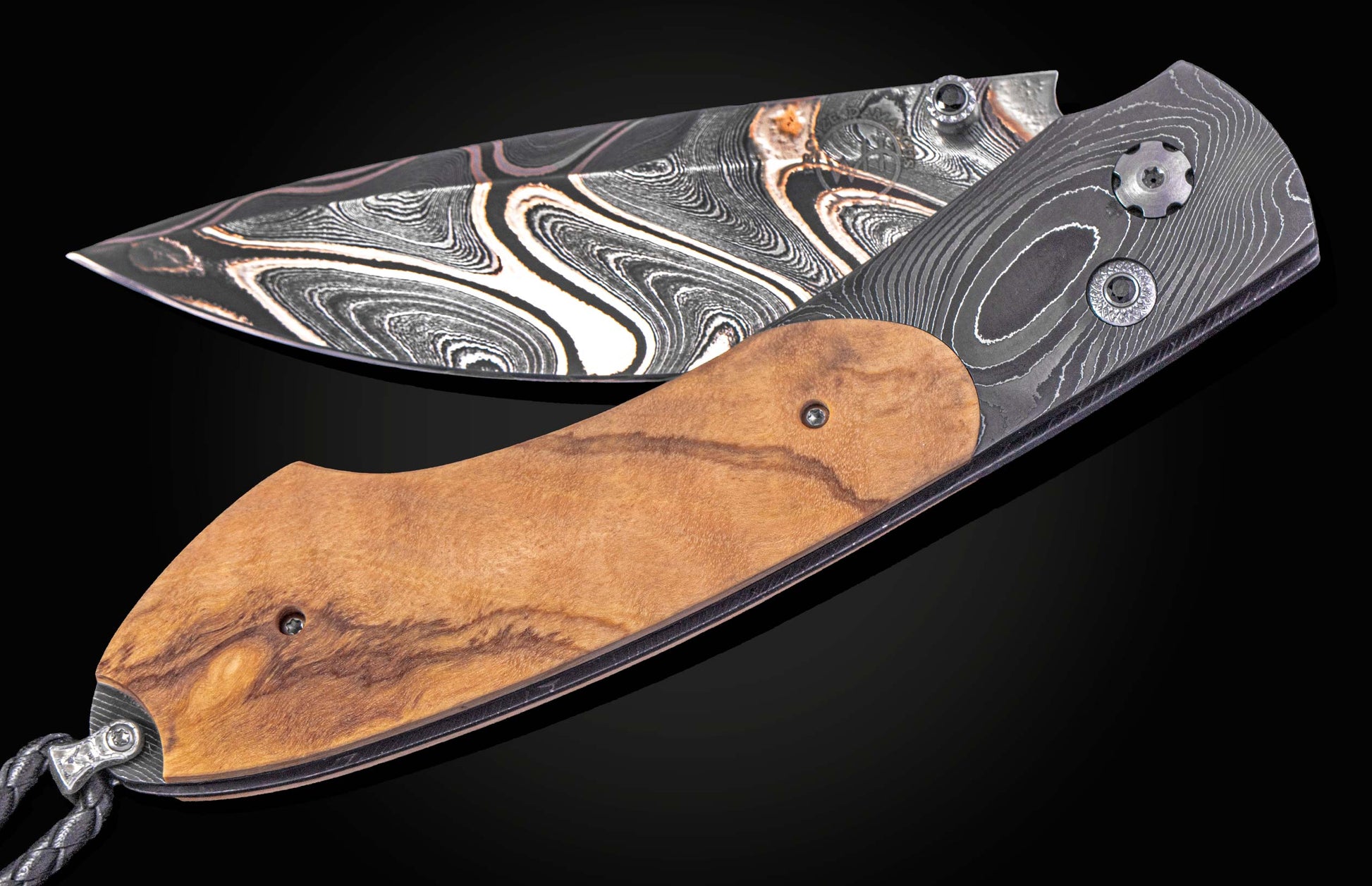 Folding knife with a wooden handle and decorative blade on a black background