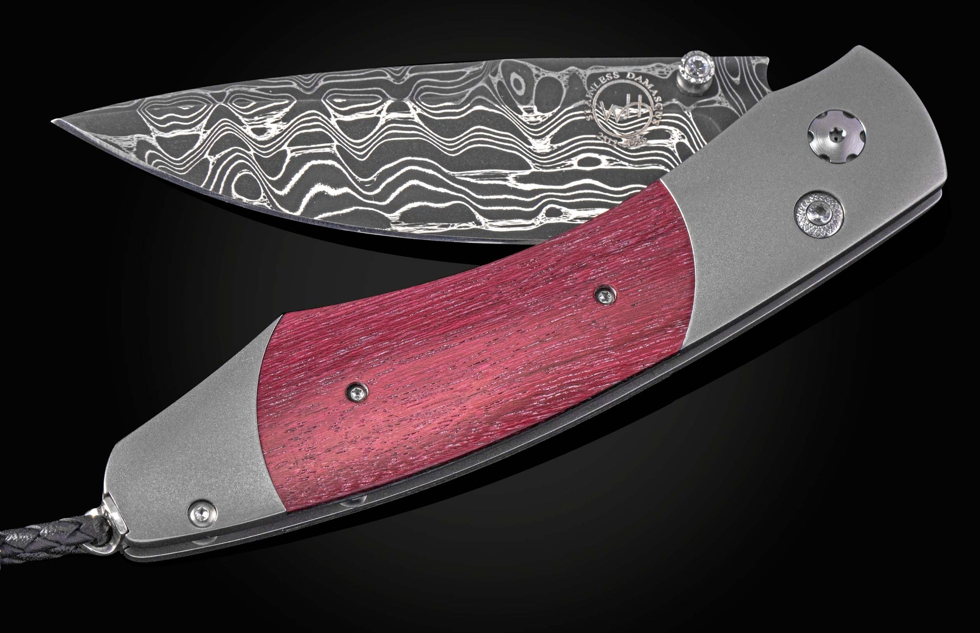 Folding knife with a purple heart wood handle and damascus blade on a black background