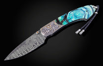 Damascus blade knife with decorative handle on a black background