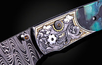 Decorative knife handle with intricate patterns and colors on a dark background