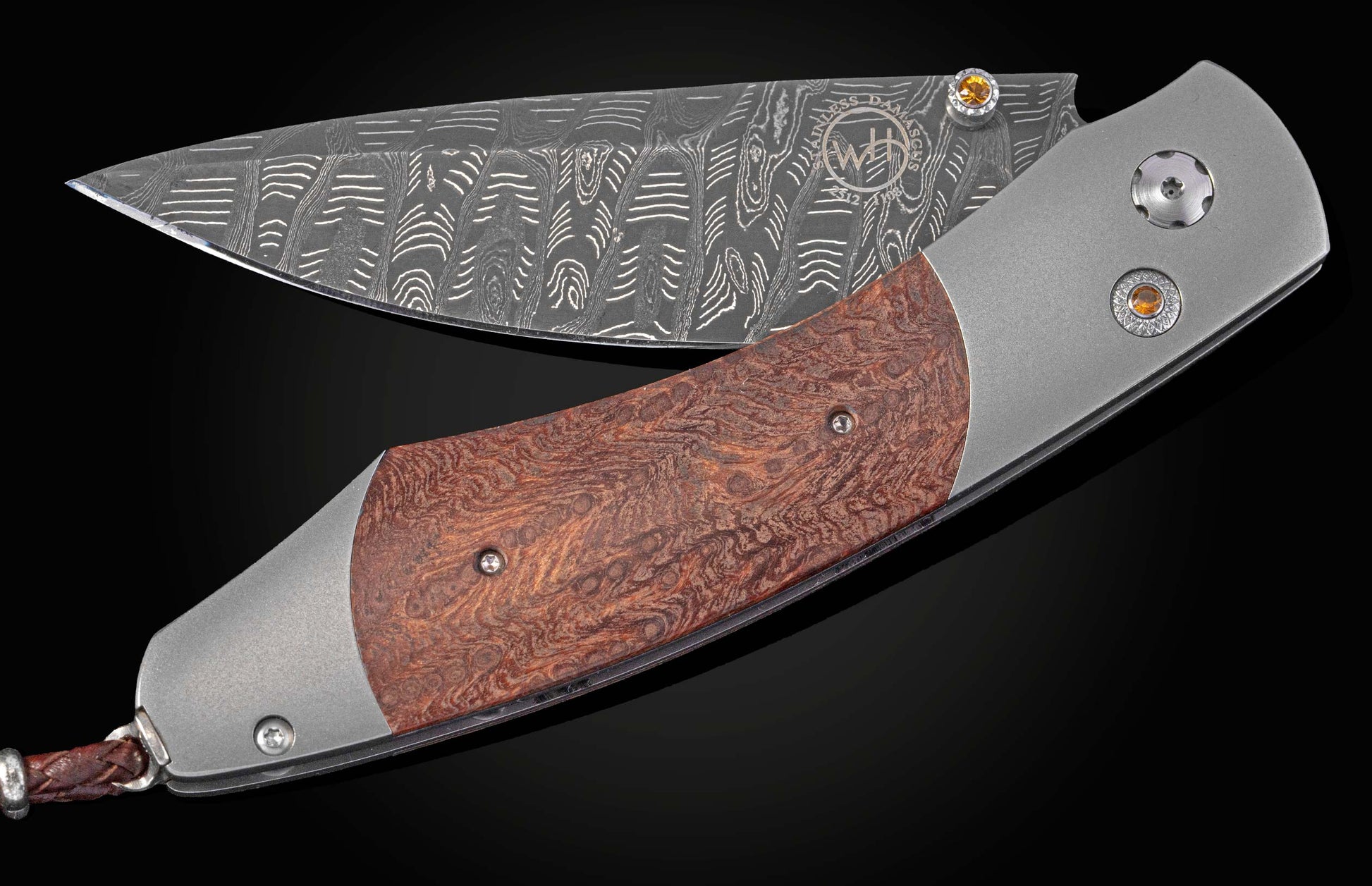 Folding knife with redwood handle and damascus blade part way open on a black background 