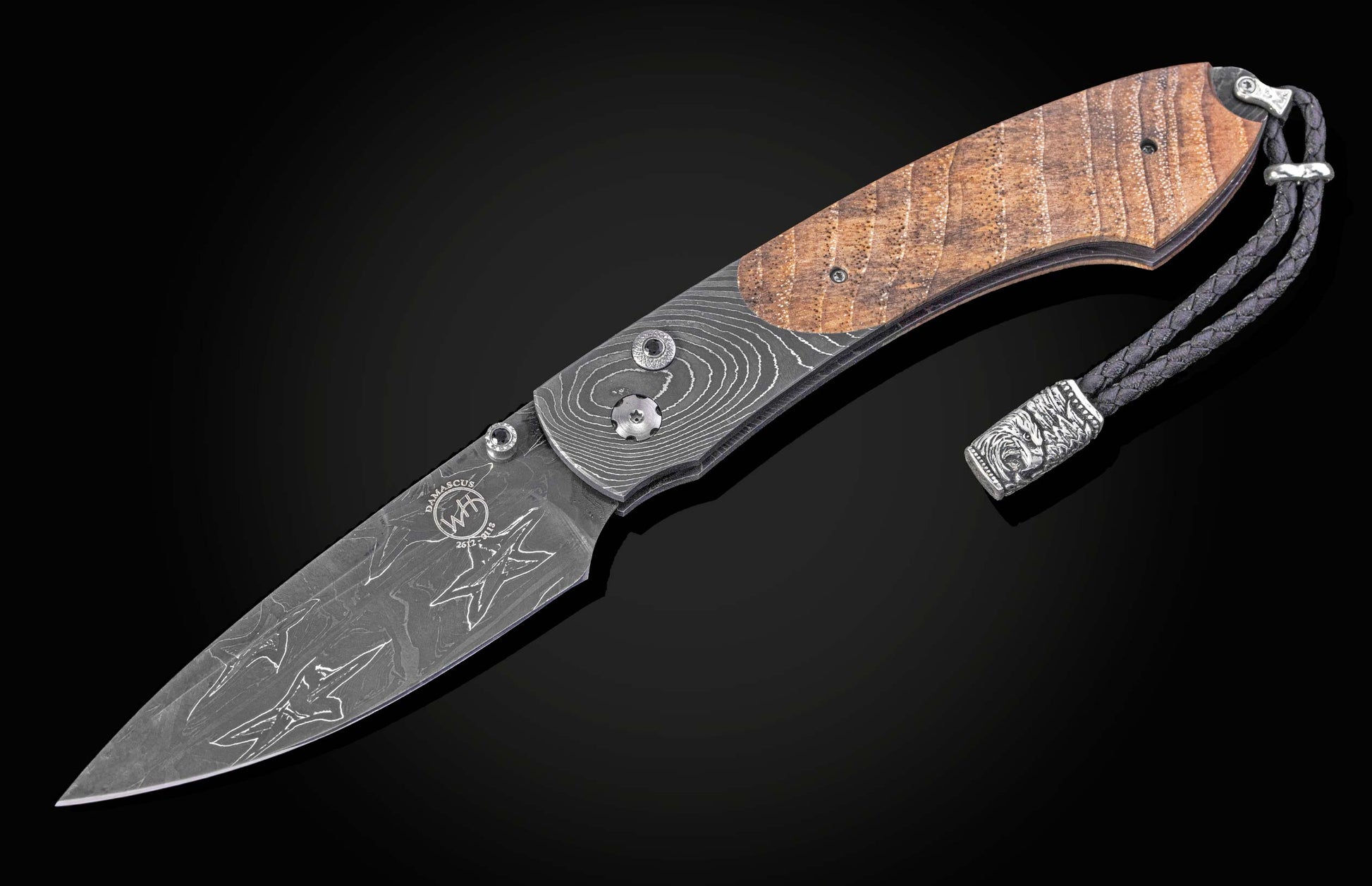 Folding knife with wooden handle and damascus blade on a black background