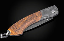 Folding knife with wooden handle and damascus blade on a black background