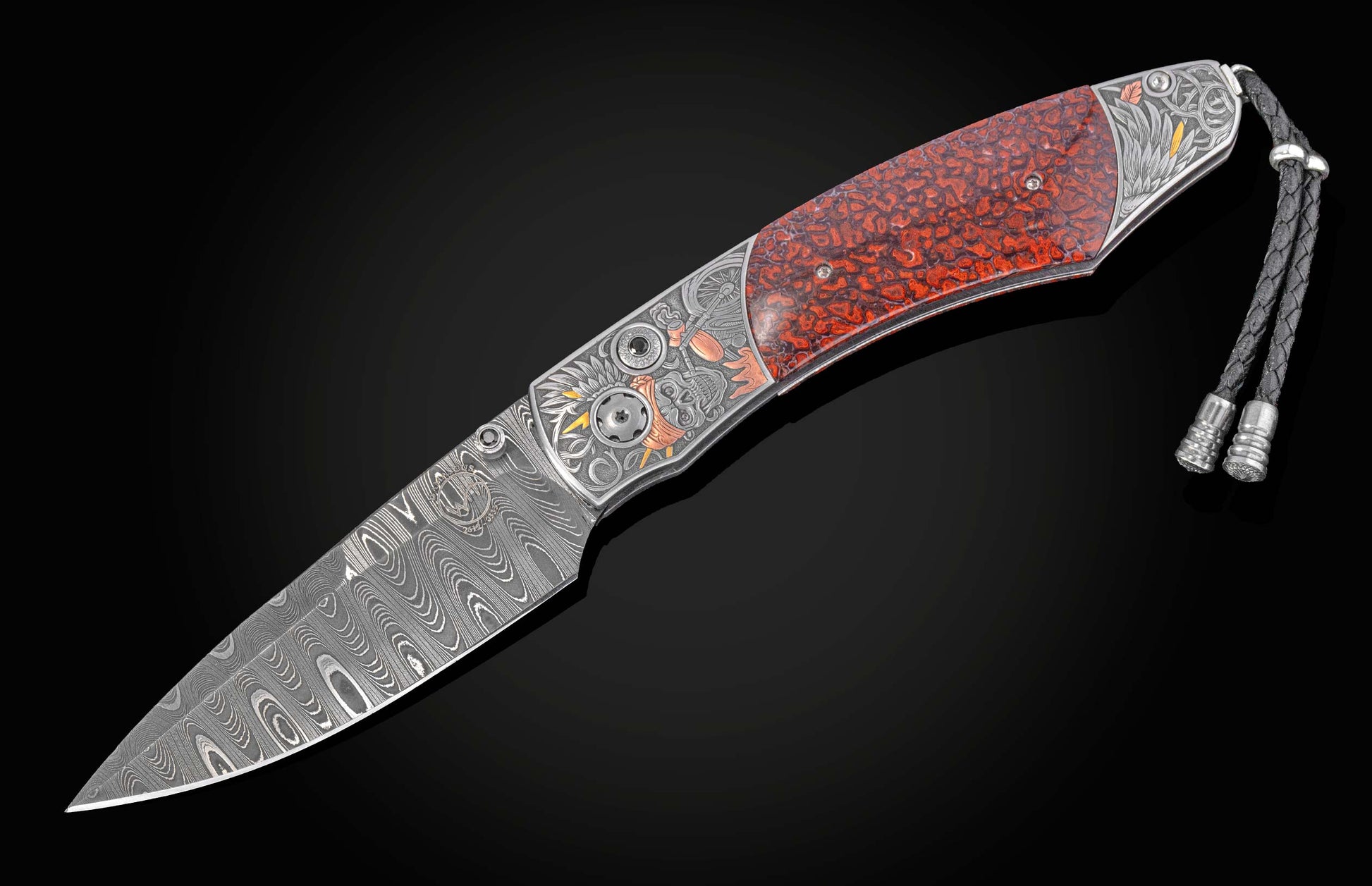 Ornate folding knife with a Damascus blade, engraved handle, red patterned scales, and a braided leather lanyard.