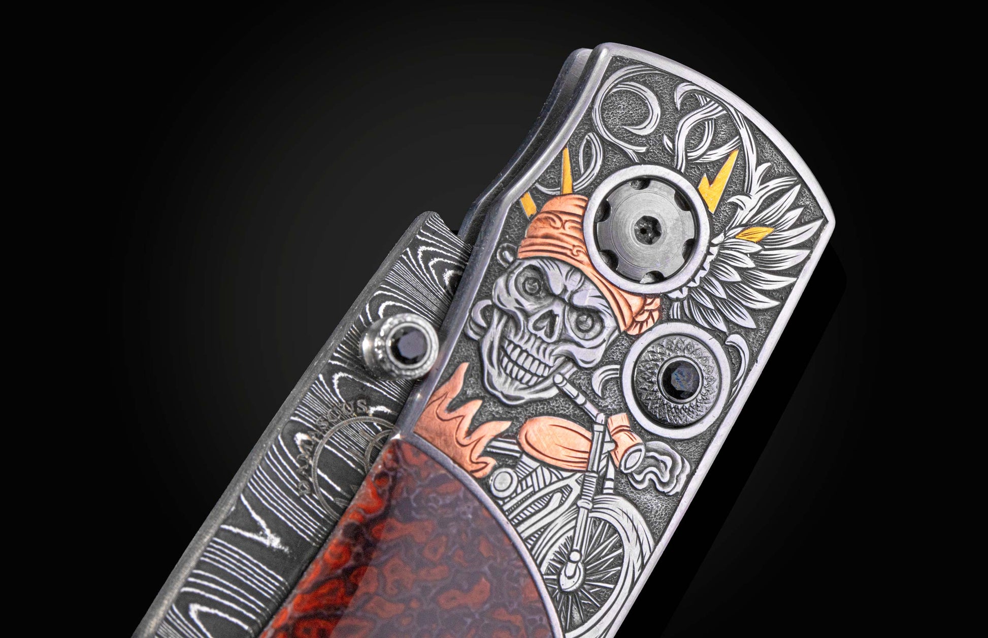 Decorative folding knife with detailed silver and copper skull and motorcycle engravings, a red patterned handle, Damascus blade, and black jewel accents.