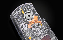 Engraved folding knife with a skull in an orange hat, microphone, wings, and lightning bolts, featuring a Damascus blade.