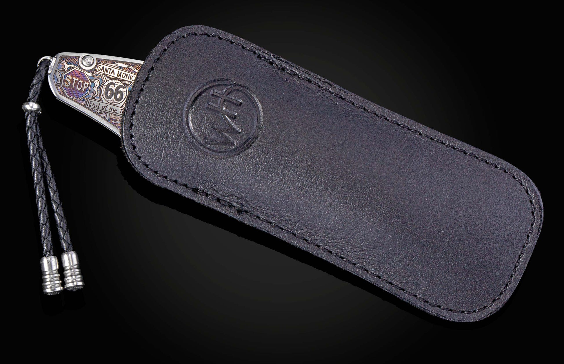 color laser engraved knife depicting scenes from Route 66 in a black leather case