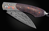Open folding knife with a Damascus steel blade featuring 'WH DAMASCUS', and an engraved handle depicting a red Shelby Cobra car, scrollwork, and dark, fiery resin.