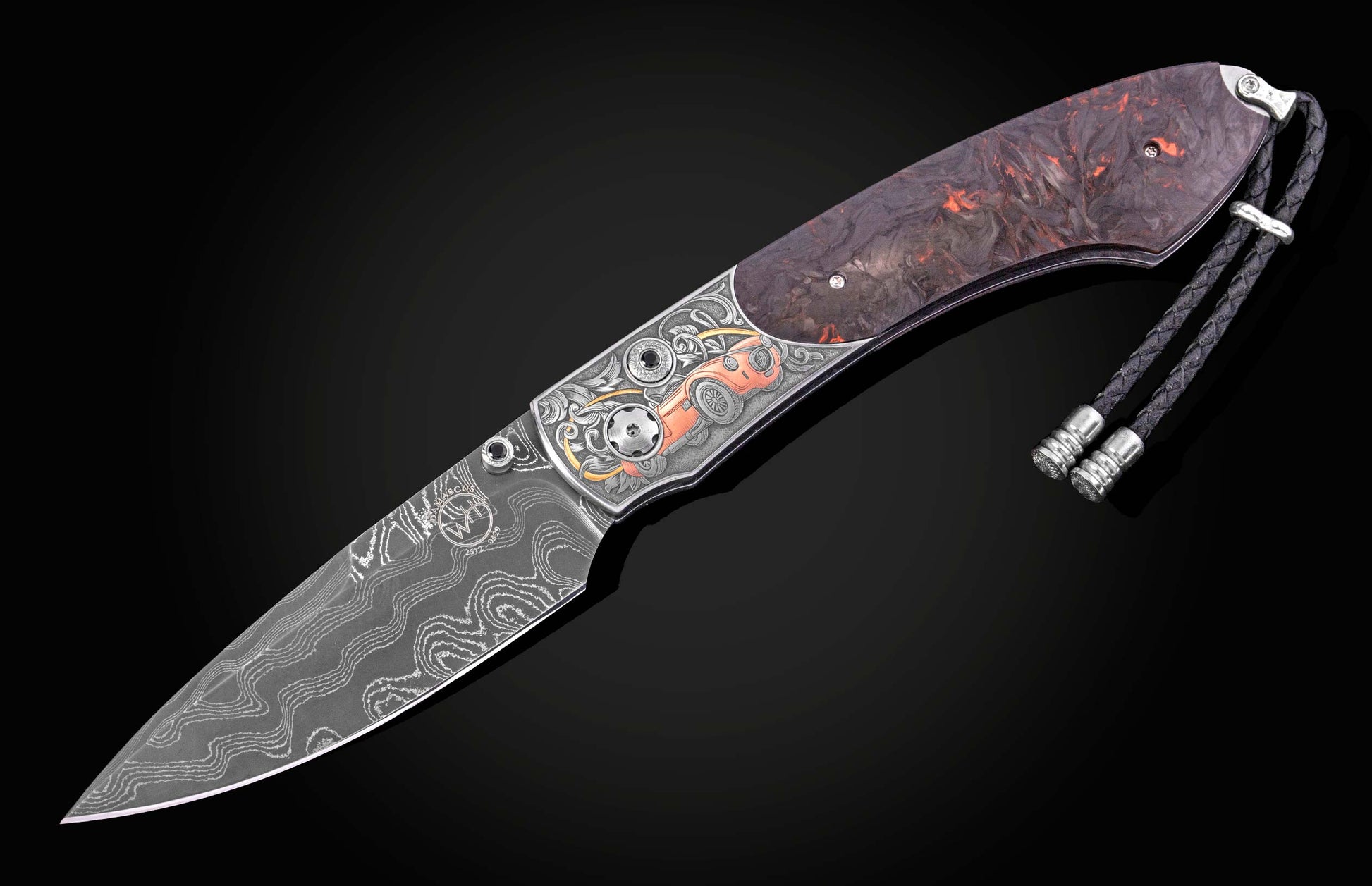 Damascus folding knife with wavy blade, dark swirled handle, silver bolster engraved with an orange Shelby Cobra, and braided black lanyard.