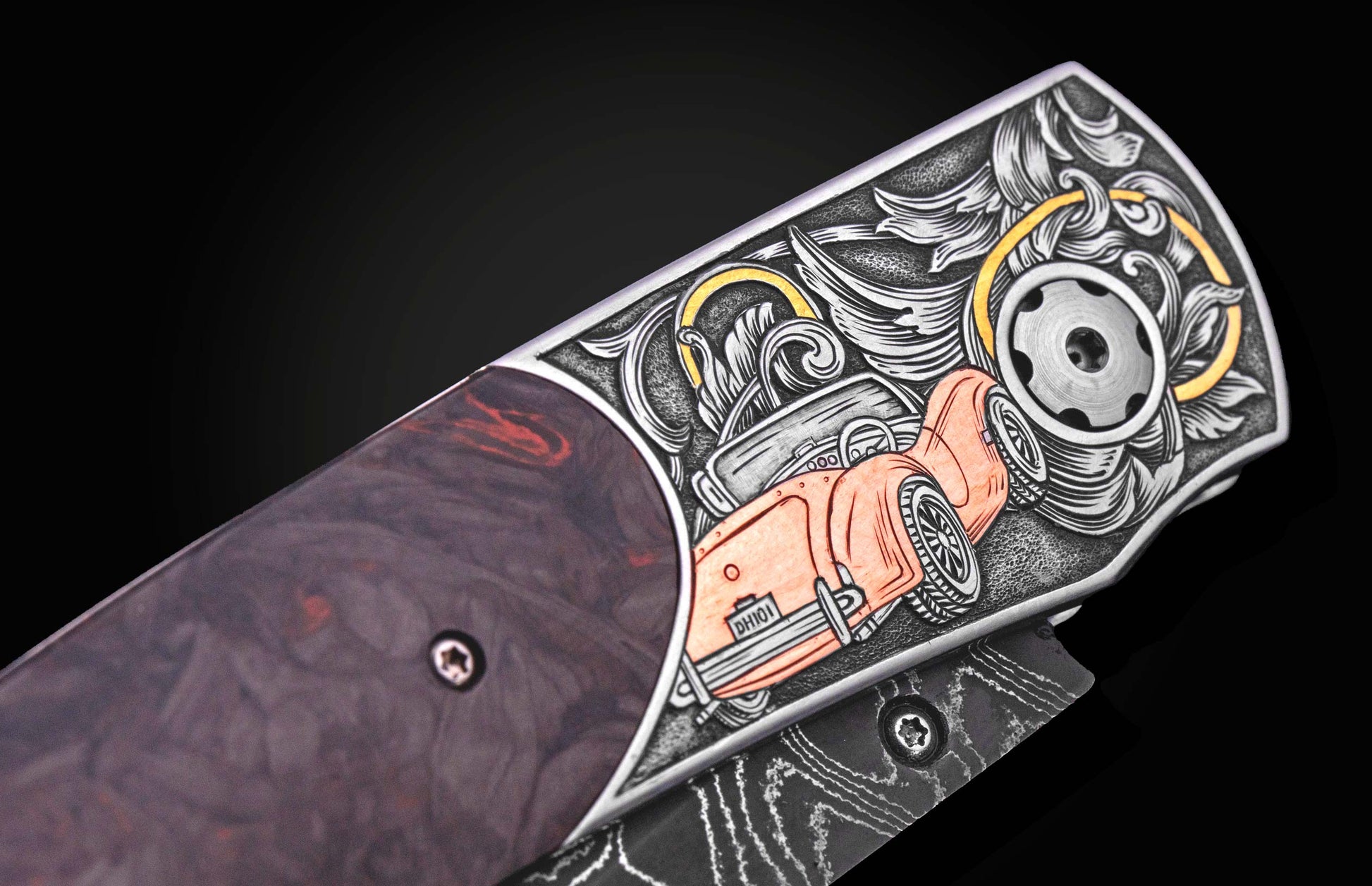 Custom knife with ornate silver engraving of an orange classic car and scrollwork, featuring a dark handle and Damascus blade.