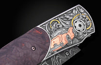 Custom knife with ornate silver engraving of an orange classic car and scrollwork, featuring a dark handle and Damascus blade.