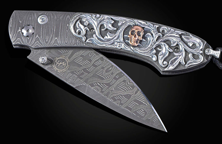 Hand carved silver folding knife with damascus steel on a black background