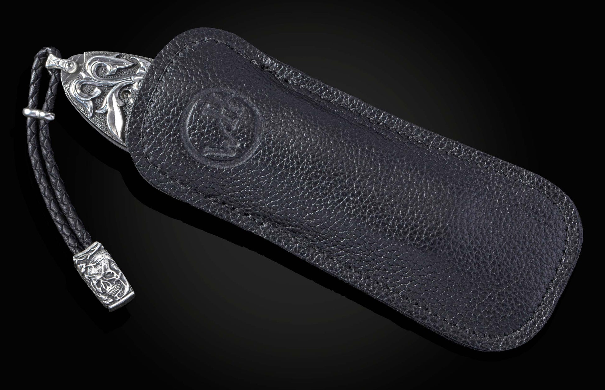 Hand carved silver folding knife with damascus steel on a black background