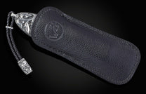 Hand carved silver folding knife with damascus steel on a black background