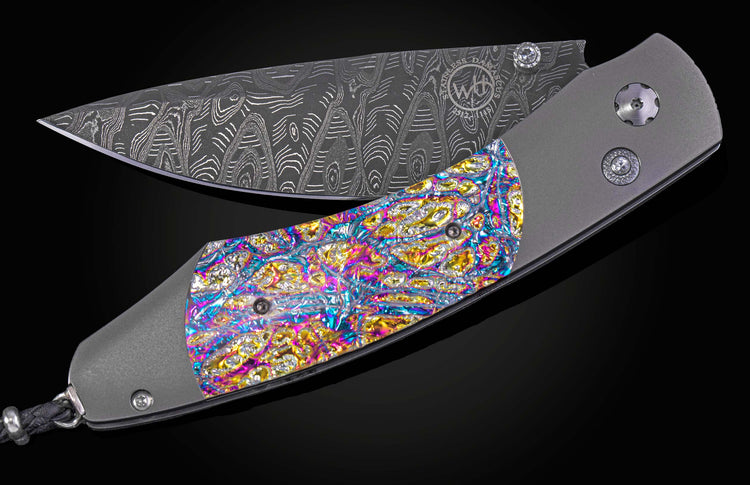 Decorative knife with colorful handle and damascus blade on a black background