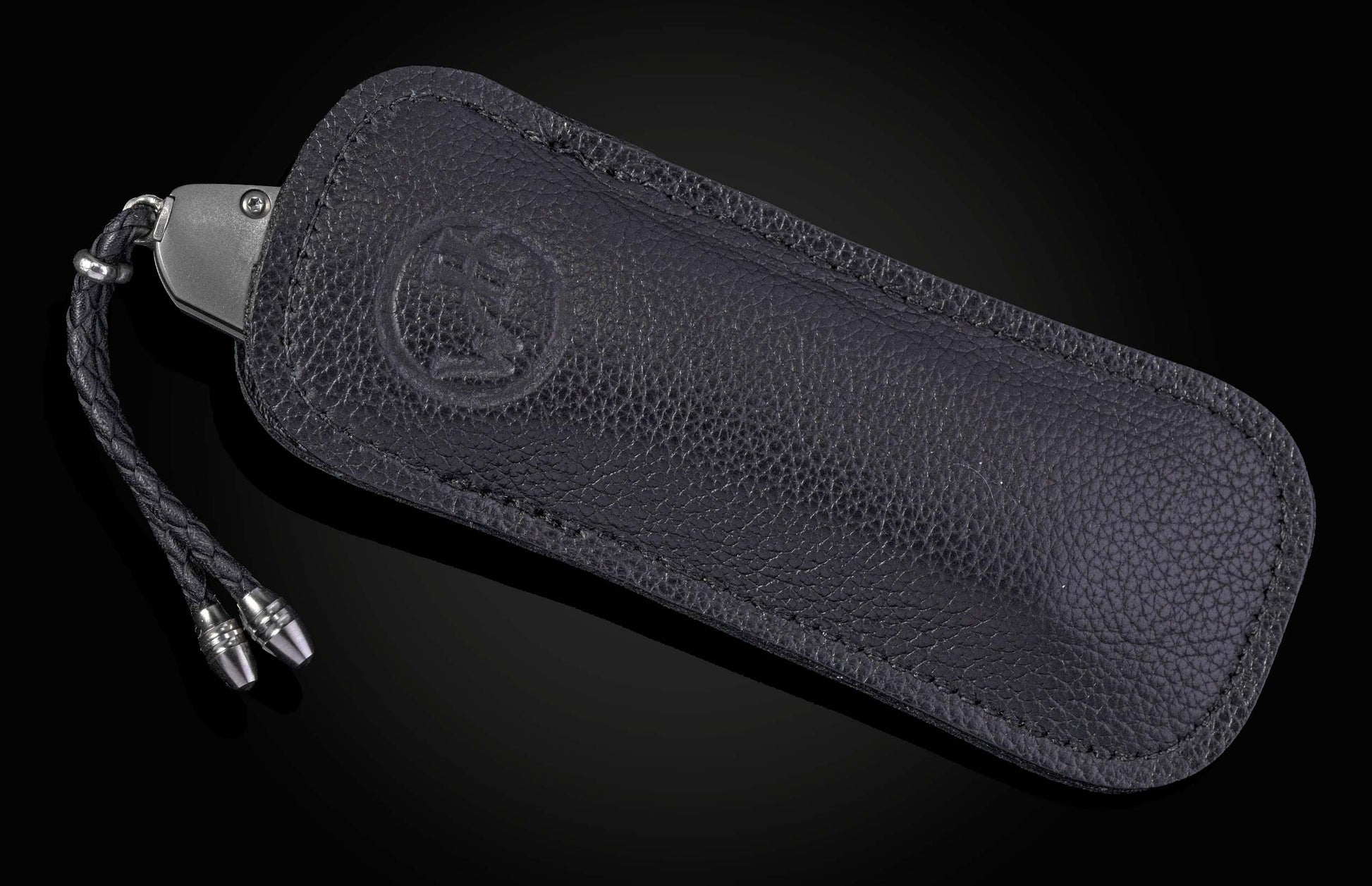 knife in black leather case on black background