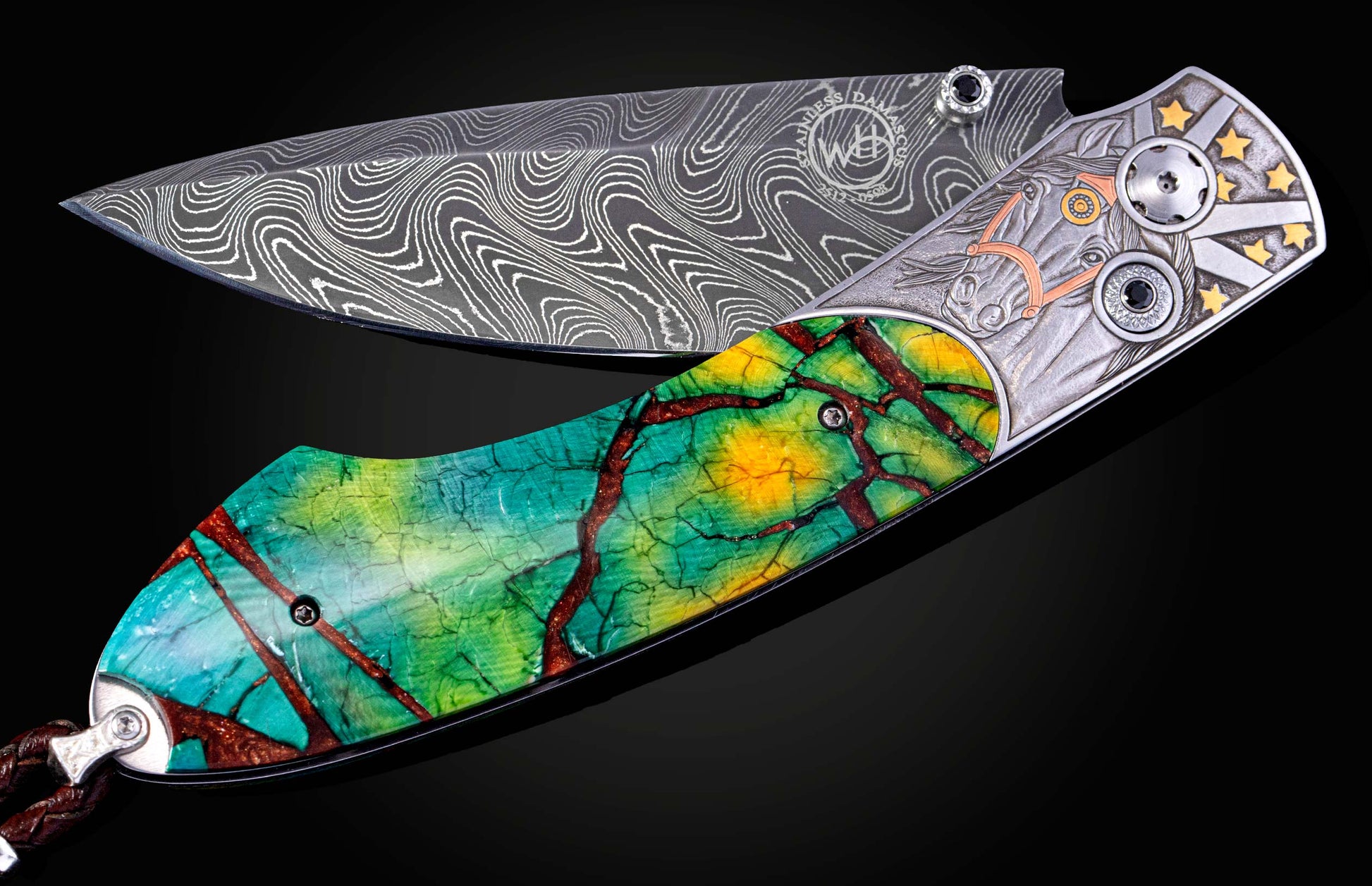 Folding knife with wavy Damascus steel blade, vibrant green and yellow handle with reddish vein patterns, and an engraved metal frame featuring a horse head and golden stars.