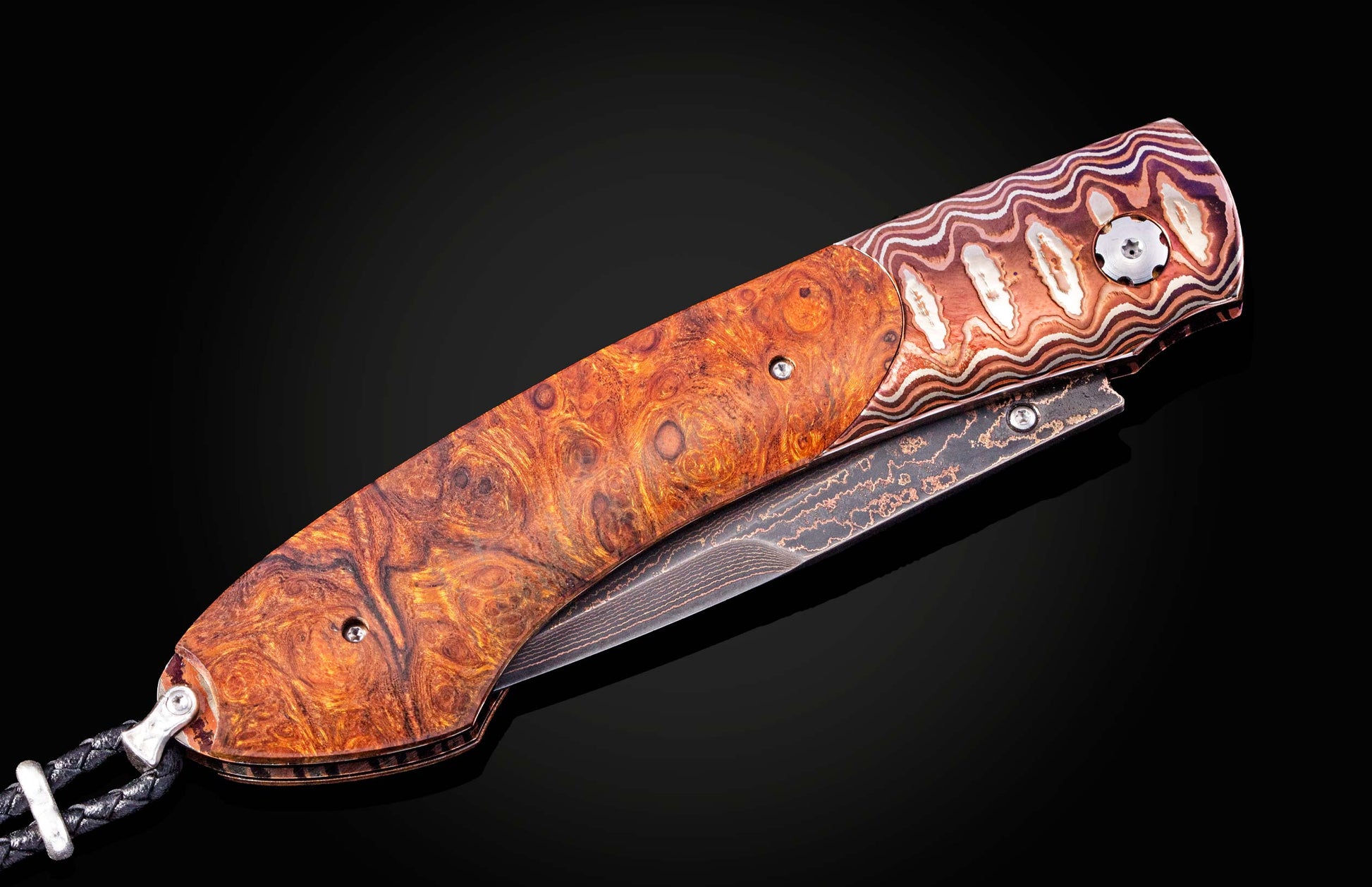 Folding knife with a decorative wooden handle on a black background